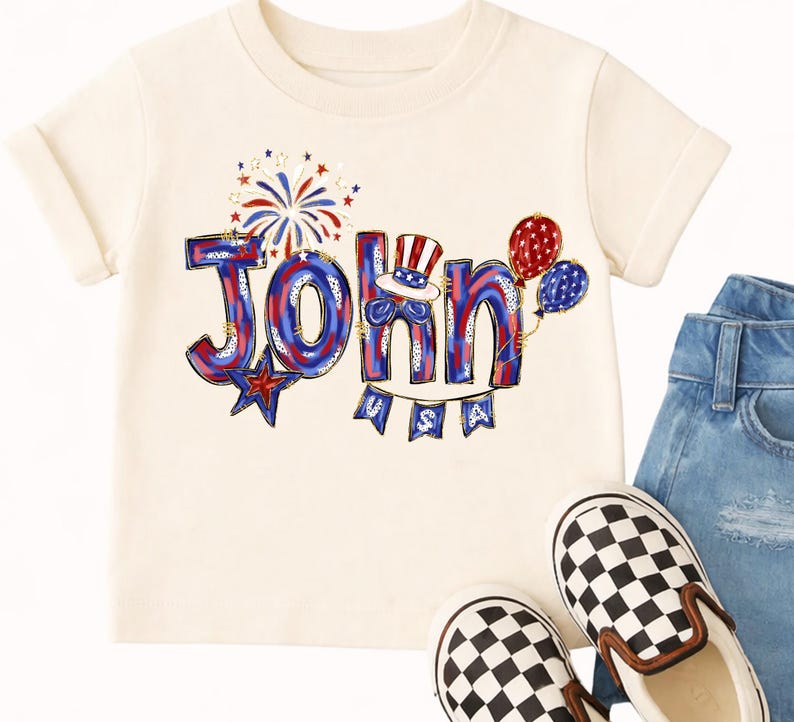 Puede incluir: Camiseta color crema con el nombre "John" en rojo, blanco y azul, decorada con fuegos artificiales, globos y una pancarta que dice "USA". La camiseta se combina con vaqueros y zapatos sin cordones a cuadros blancos y negros.