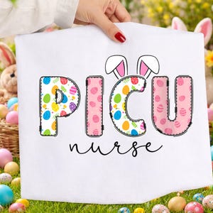 May include: White fabric with the text "PICU nurse" in a colorful Easter egg design. The letters are outlined in black with a stitched effect. Bunny ears are above the "ICU". The background includes Easter eggs and a basket.