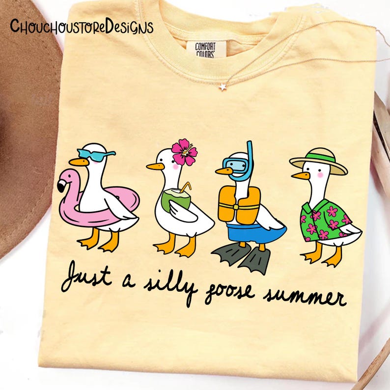 May include: Yellow t-shirt with a graphic of four cartoon geese, each accessorized for summer fun. One wears sunglasses and a flamingo floatie, another a flower, a third a snorkel, and the last a Hawaiian shirt. Text reads "Just a silly goose summer."