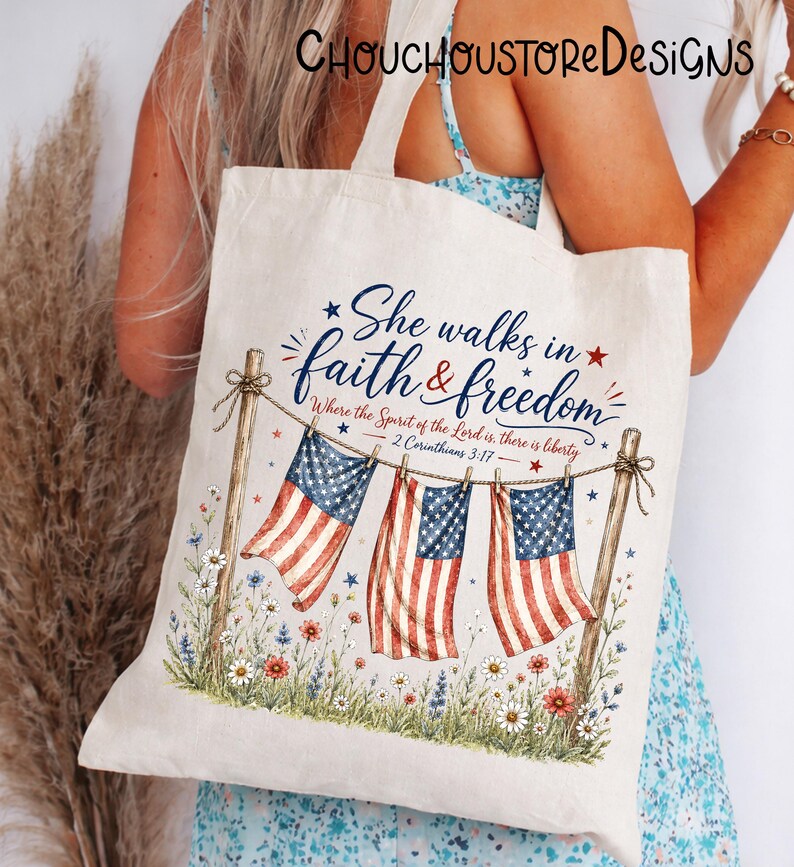 May include: Cream-colored tote bag featuring the text "She walks in faith & freedom" with American flags and floral accents. The design includes the scripture 2 Corinthians 3:17. The bag has a patriotic theme.