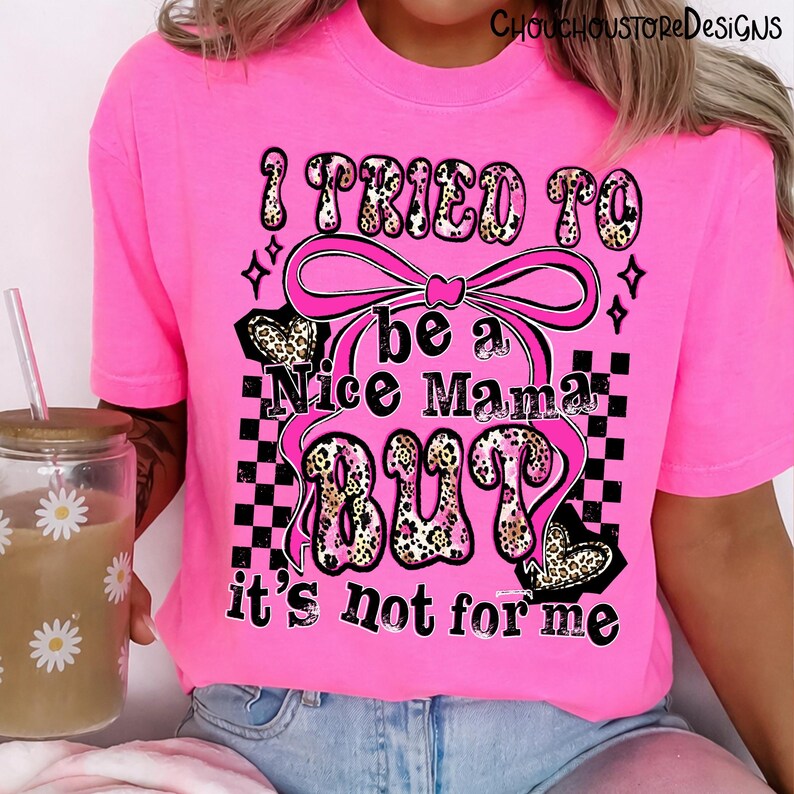 May include: Bright pink t-shirt with the text "I TRIED TO be a Nice Mama BUT it's not for me." The text features a leopard print design and is accented with a pink bow and black and white checkered pattern.