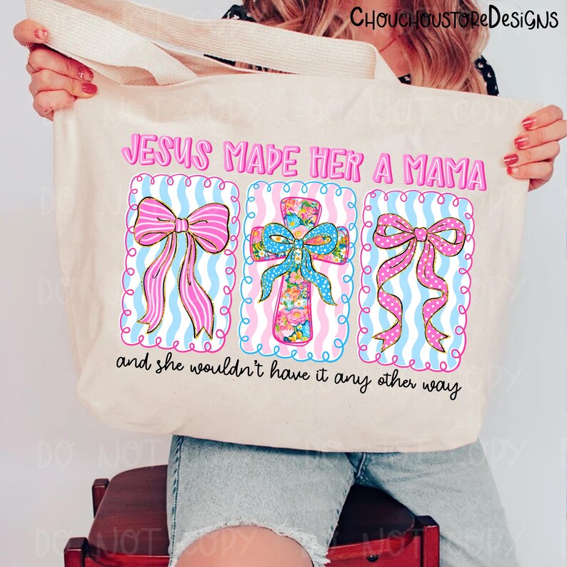 May include: Beige tote bag with the text "JESUS MADE HER A MAMA" and "and she wouldn't have it any other way." The design features three decorative elements: two bows and a cross, all in pink, blue, and floral patterns.