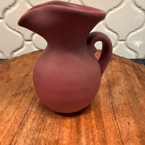 May include: A rustic wooden sign with the text "Welcome to our porch" in white lettering. The sign features a distressed finish and a simple, inviting design, perfect for outdoor decor.