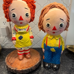 May include: A set of three ceramic mugs with a speckled, matte finish. The mugs are in shades of cream, light gray, and dark gray. Each mug has a simple, minimalist design, perfect for coffee or tea.