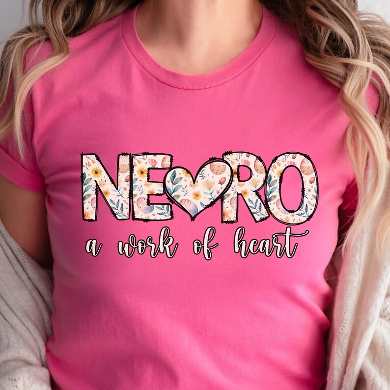 May include: Pink t-shirt with a floral design that says "NERO a work of heart".