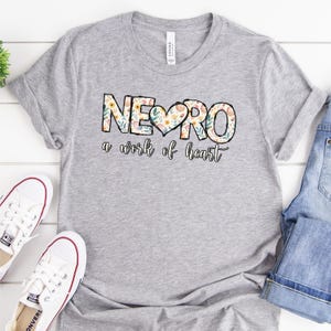 May include: A gray t-shirt with a floral design that says "NEURO a work of heart".