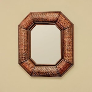 May include: An octagonal wall mirror featuring a frame constructed from dark brown woven rattan material. The mirror has a central reflective glass pane surrounded by eight distinct segments of textured, interlaced natural fiber strips.
