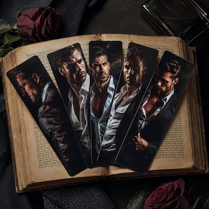 May include: Five rectangular bookmarks featuring portraits of men in suits and unbuttoned white shirts, arranged in a fan shape on an open antique book. The bookmarks display various poses of individuals with dark hair, set against a dark, moody background.