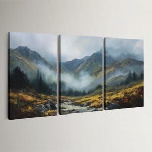May include: A three-panel canvas print of a mountain scene. The artwork shows a river flowing through a valley, with mountains in the background. The colour scheme includes greens, yellows, and greys, with a misty atmosphere.
