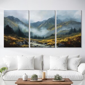 May include: A three-panel canvas print showing a mountain landscape. A river flows through a valley, with mountains in the background. The colour palette includes shades of green, yellow, and grey, creating a tranquil and natural scene.
