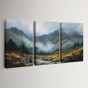 May include: A three-panel canvas print of a mountain landscape. The artwork shows a valley with a river, framed by mountains and trees. The sky is misty, and the colour scheme includes green, yellow, and brown hues.