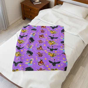 May include: A purple blanket featuring a repeating pattern of colorful cartoon dragons and yellow stars. The dragons are in various poses and colors, creating a whimsical and playful design. The blanket is displayed on a white bed.