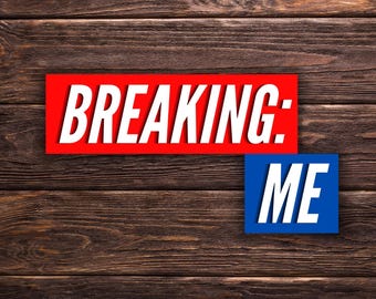 Può includere: Un cartello rettangolare rosso con il testo bianco BREAKING: e un cartello rettangolare blu più piccolo sotto con il testo bianco ME. Entrambi i cartelli sono posizionati su uno sfondo a venature del legno marrone scuro con assi orizzontali.