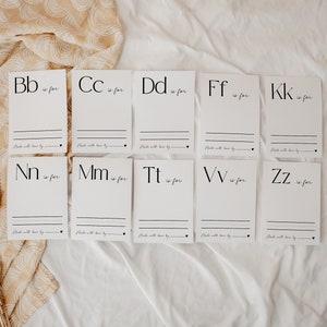 May include: Ten white rectangular cards featuring black printed letters of the alphabet including Bb, Cc, Dd, Ff, Kk, Nn, Mm, Tt, Vv, and Zz. Each card includes the text 'is for', three horizontal lines for writing, and 'Made with love by' at the bottom.