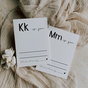 May include: Two white cards with black text. The first card says "Kk is for" and the second card says "Mm is for". Both cards have a line for writing and the text "Made with love by."