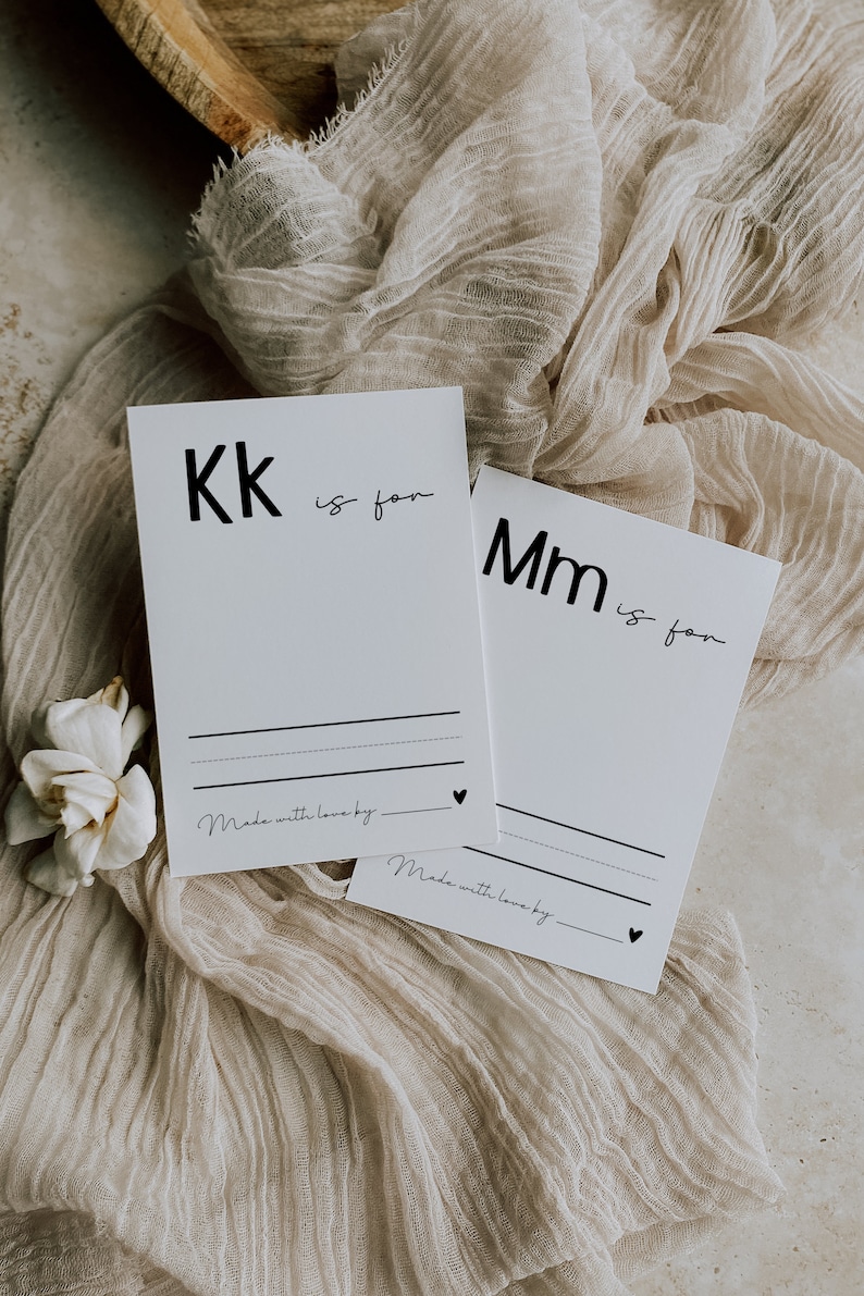 May include: Two white cards with black text. The first card says "Kk is for" and the second card says "Mm is for". Both cards have a line for writing and the text "Made with love by."