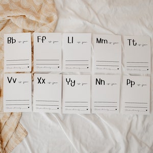 May include: Ten white cards with black lettering. Each card features a letter of the alphabet and the phrase "is for". The cards are arranged in two rows of five.