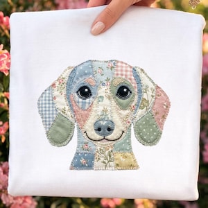 May include: A white square fabric with an embroidered patchwork dog design. The dog's face is composed of various fabric patches in pastel colors and floral patterns. The dog has large, black eyes and a smiling expression, creating a charming and whimsical aesthetic.