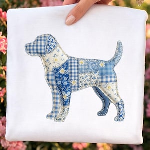 May include: A white square textile featuring a patchwork dog. The dog is constructed from blue and white floral and gingham fabrics. The dog's form is stitched onto the white fabric, creating a decorative item.
