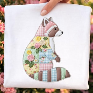 Könnte beinhalten: Ein weißes quadratisches Textil mit einem Patchwork-Waschbär-Design. Der Waschbär hat einen rosa und braunen Kopf, und sein Körper besteht aus floralen und Vichy-Mustern. Das Design umfasst gestickte Blumen und Blätter mit einem Perlenrand.
