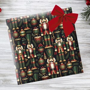 May include: A wrapped gift with a red bow. The wrapping paper features a repeating pattern of nutcrackers, ornaments, and drums in red, green, and gold on a black background. Christmas-themed.