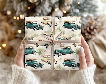 May include: White wrapping paper with a repeating pattern of vintage cars in shades of green and cream. The cars are driving on a white road with palm trees on either side.