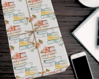 May include: White gift wrap with a repeating pattern of stacks of books, teacups, and flowers. The books are illustrated in shades of blue, green, yellow, and red. The teacups are white with a light blue rim. The flowers are pink, orange, and white.