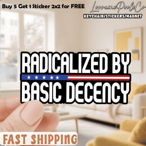 May include: A white ceramic mug with a black handle and the text "But First, Coffee" in black. The mug is filled with a dark liquid, probably coffee, and is placed on a light-coloured surface.