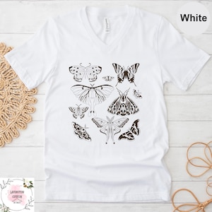 A white t-shirt with a graphic design of various butterflies printed on it.