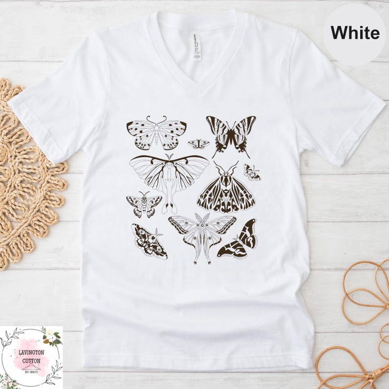 A white t-shirt with a graphic design of various butterflies printed on it.