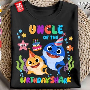 Puede incluir: Una camiseta negra con un gr&aacute;fico colorido y el texto "UNCLE OF THE BIRTHDAY SHARK". El dise&ntilde;o incluye dos tiburones de dibujos animados con gorros de fiesta, un pastel de cumplea&ntilde;os, una estrella de mar, un pez peque&ntilde;o y algas verdes.