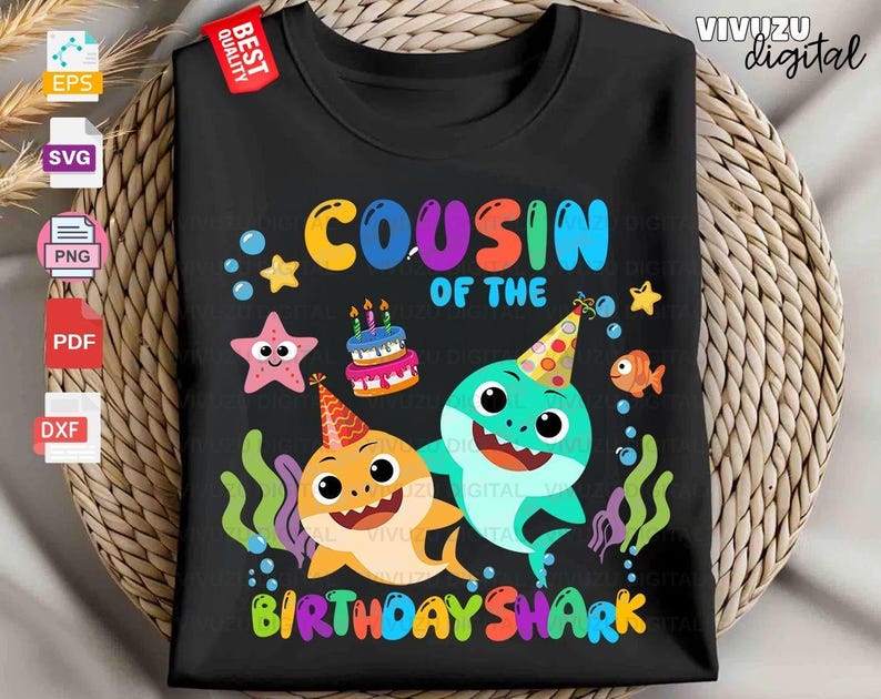 Puede incluir: Una camiseta negra con un gr&aacute;fico colorido y el texto "COUSIN OF THE BIRTHDAY SHARK". El dise&ntilde;o incluye dos tiburones de dibujos animados con gorros de fiesta, un pastel de cumplea&ntilde;os, una estrella de mar, un pez naranja, burbujas y algas.