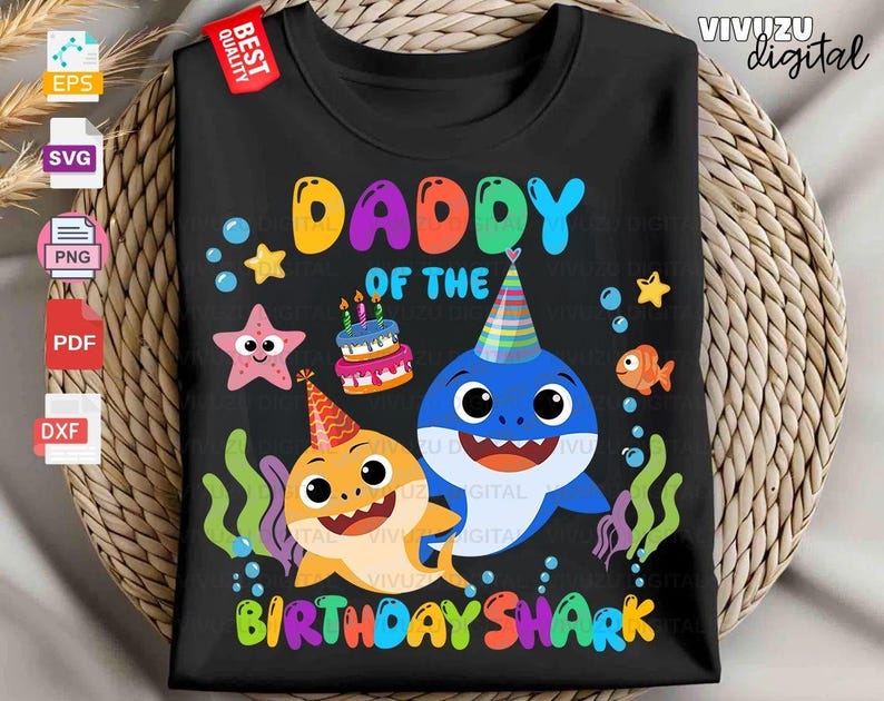 Puede incluir: Una camiseta negra con un gr&aacute;fico colorido de dos tiburones con gorros de fiesta, un pastel de cumplea&ntilde;os, una estrella de mar y un pez. El texto DADDY OF THE BIRTHDAY SHARK aparece en letras multicolores, rodeado de burbujas y algas.