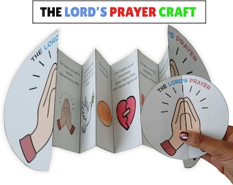 Op de afbeelding: Een gevouwen papieren knutselwerk met de titel "THE LORD'S PRAYER CRAFT" met illustraties van biddende handen, een duif en een gebroken hart. De tekst van het Onze Vader staat op de binnenpanelen.