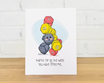 May include: A greeting card with a cartoon illustration of a gray character holding a stack of colorful dumbbells. The text on the card reads "Thanks for all the ways you have lifted me."
