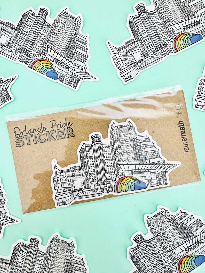 Puede incluir: Una hoja de pegatinas con seis pegatinas que muestran una ilustraci&oacute;n en blanco y negro del horizonte de Orlando con un arco&iacute;ris sobre los edificios. La hoja de pegatinas tiene el texto "Orlando Pride STICKER".