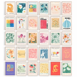 May include: A set of 20 colourful art prints featuring various floral designs, abstract shapes, and text. The prints are framed in a light wood frame and feature the names of famous artists such as Matisse, Picasso, and Yayoi Kusama.