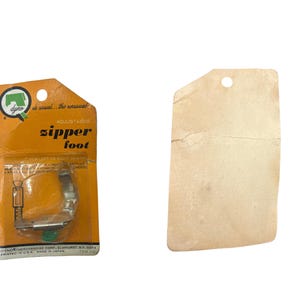 May include: Vintage Dyno zipper foot for sewing machines, in original packaging. The orange and yellow packet features the words "zipper foot". The metal foot is visible through the clear plastic, with a green screw.
