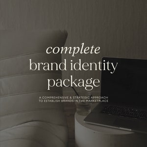 May include: A white text graphic on a gray background reads "complete brand identity package" with the tagline "A comprehensive & strategic approach to establish brands in the marketplace". A laptop computer and a glass of water are on a white table in the background.
