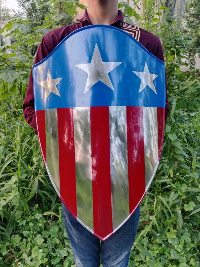 May include: A red, white, and blue shield with five stars. The shield is made of metal and has a shiny finish.