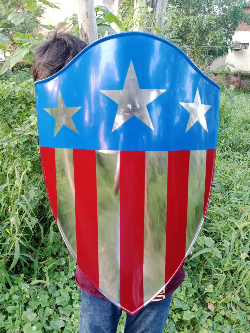 May include: A red, white, and blue shield with five pointed stars. The shield is made of metal and has a shiny finish.
