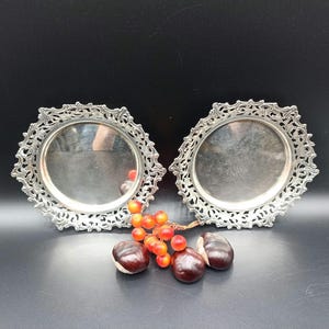 Two silver bottle holders, openwork cut out with a floral representation.