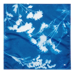 Pode incluir: Um tecido azul com um padrão floral branco. O tecido é texturizado e tem um aspecto ligeiramente desbotado.