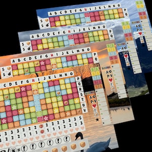 以下が含まれることがあります： 色とりどりのゲームボードには、それぞれ異なる色と記号が書かれた正方形のグリッドがあります。ボードは、文字と数字でラベル付けされたセクションに分割されています。ゲームボードは、湖と山の背景に設定されています。ゲームボードは、より大きなゲームセットの一部です。