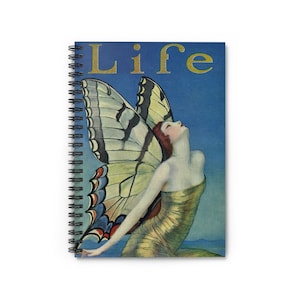 May include: Spiral-bound notebook featuring a vintage illustration of a woman with butterfly wings. The cover art includes the word "LIFE" in gold lettering against a blue background. The woman is wearing a gold dress.