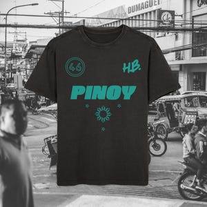 May include: Black t-shirt with teal text and graphics. The word "PINOY" is prominently displayed, along with the number "46" in a circle and the initials "HB." Below the word "PINOY" is a sunburst design and three stars.