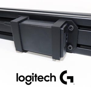 May include: Close-up of a black electronic device with a rectangular body and a cable. The device is attached to a black bar. The Logitech G logo is visible at the bottom.