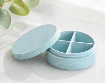 Pastillero redondo con 4 compartimentos: compacto, elegante e ideal para llevar a todas partes; disponible en varios colores.