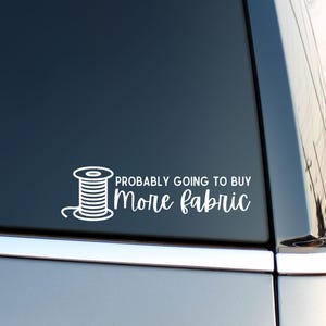 May include: White vinyl decal with a spool of thread and the text "Probably going to buy more fabric".