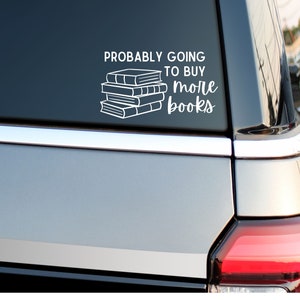 May include: White vinyl sticker on a gray car with the text "Probably going to buy more books" and a stack of books.